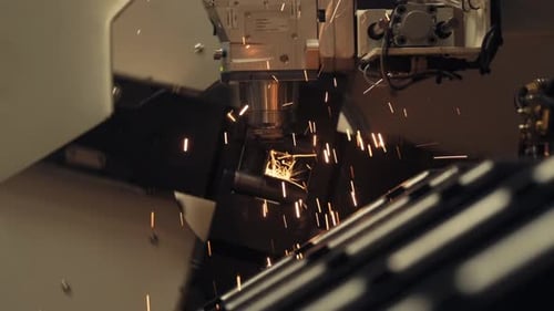 Automatic CNC laser cut machine while cutting the metal part with the sparking light. modern factory