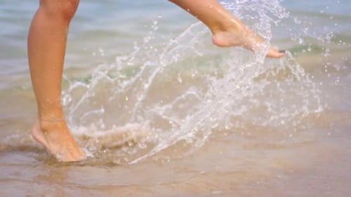 Female Legs in Sea Waves. Close Up of Woman Legs Walking On