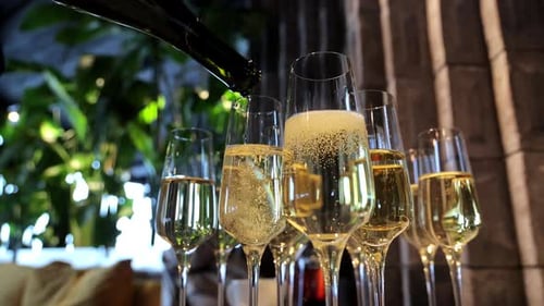 Pouring Champagne Into Multiple Glasses at a Festive Celebration Closeup View of Sparkling Wine