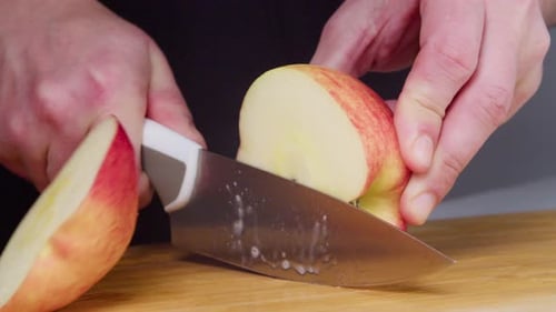 Slicing a Ripe Red Apple on Wooden Board