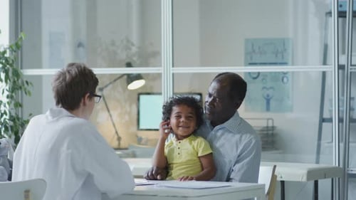 Doctor Consulting with Child Patient and Senior Man