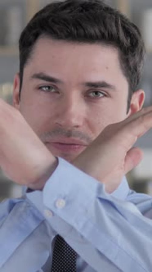 Young Man Gesturing a Stop Sign with His Arms