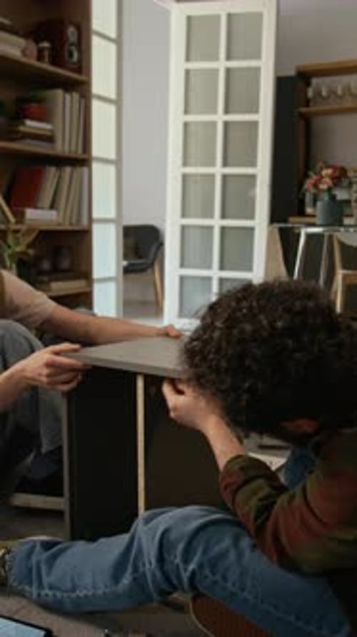 Husband and Wife Assembling Drawer Together and Giving High Fives