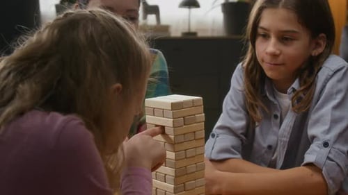 Mother and Kids Playing Wooden Blocks Tower Game at Home