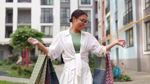 Woman With Shopping Bags Dancing In City