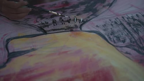 Slow motion close up shot of a painting hand with a black brush with white acrylic paint. Painting a