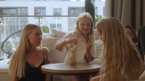 Familie spielt zu Hause zusammen ein kreatives Balance-Stacking-Spiel aus Holz
