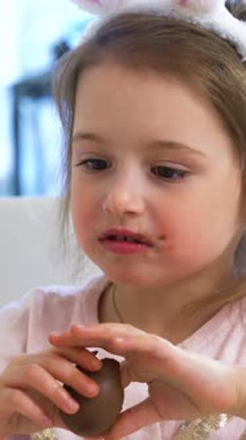Mother And Daughter Eating Chocolate Easter Eggs