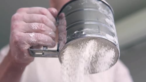 Close Up of Person Sifting White Flour