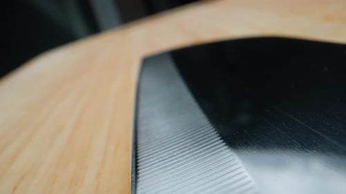 Couteau de cuisine sur une planche à découper en bois en vidéo macro. 4K