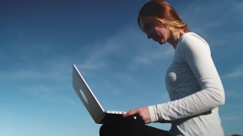 Woman using laptop in the mountains