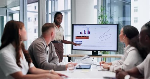 Woman Presents to Colleagues at Conference Table