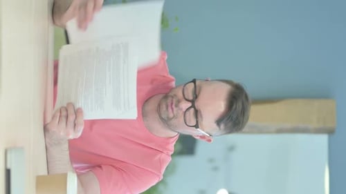 Man Reads Paperwork at a Desk