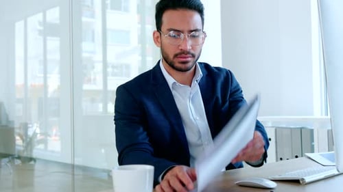 Data analyst reading paperwork sitting marketing statistics reports