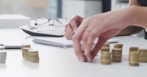 4k video footage of an unrecognizable businesswoman stacking coins while working in her office