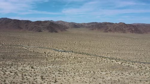 Luftbild der Straße inmitten von kargem Land in der Nähe des Joshua-Tree-Nationalparks in Kalifornien, USA.