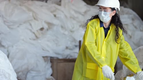 Blackhaired Lady Worker in Mask Sorts Trash at Waste Plant