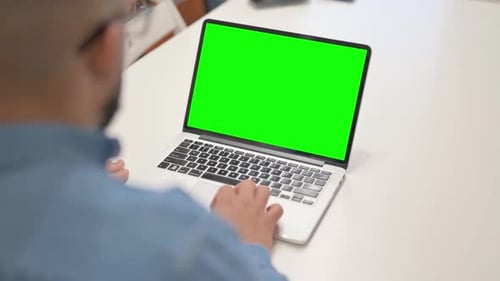 African Man Working on Laptop with Green Screen