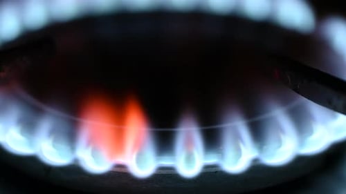 Brennendes Gas. Es wird aus der Dunkelheit beleuchtet und erlischt.