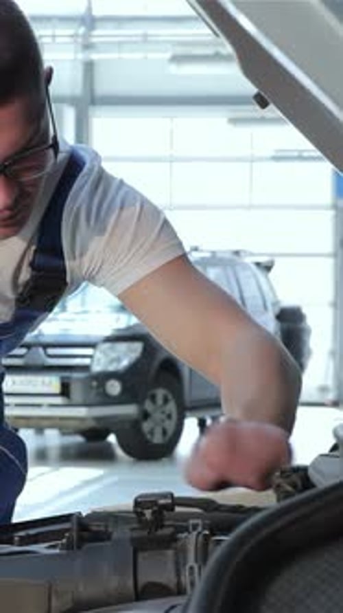 Un mécanicien spécialisé inspecte méticuleusement le moteur de la voiture pour des performances optimales