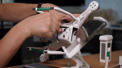 Closeup of a Man Assembling a Quadcopter in the Studio A Man Repairs a Drone