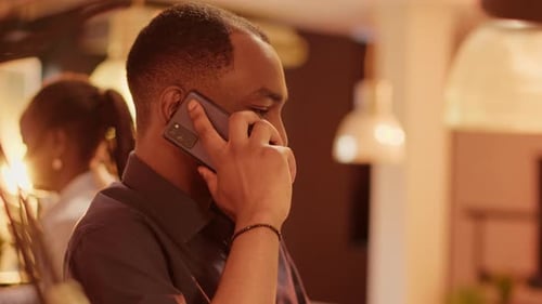 African American Man Talking on Mobile Phone Call at Office Desk