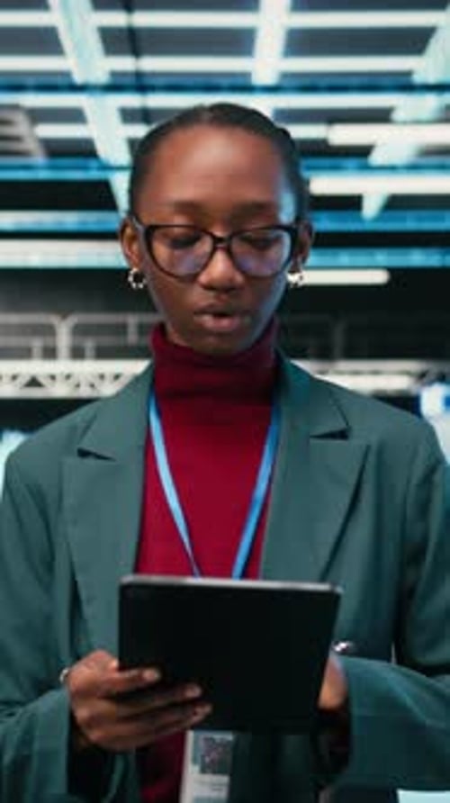 Vertical Video Female Engineer Walks in Data Center Using Tablet and AR Tech to Monitor Errors