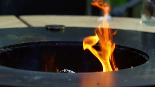 Close up fire flames burning on empty bbq grill outdoors in summer evening