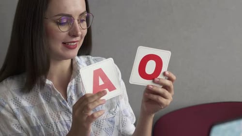 Woman Holds Alphabet Cards for Education Lesson