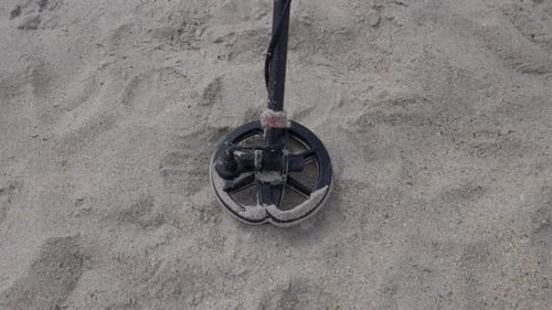 Metal detector scans beach close up. looking for treasure. video of advanced technology looking for