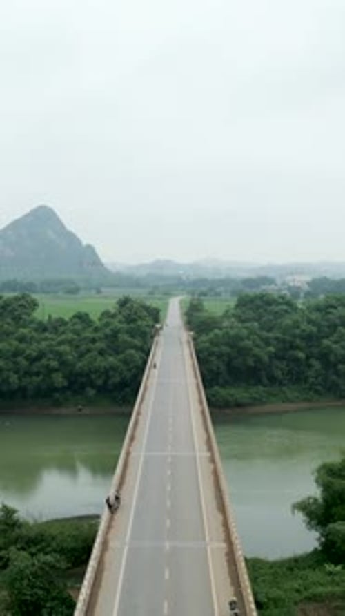 Drone Flying Over the Long Bridge That Crosses the Big River Between the Mountains of Vietnam
