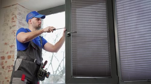 Construction Worker Fixing Window Latch with Screwdriver