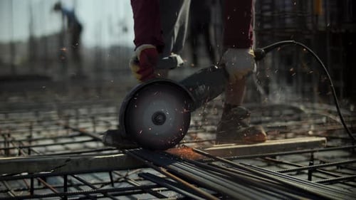 Worker Cutting Steel Rebar with Angle Grinder