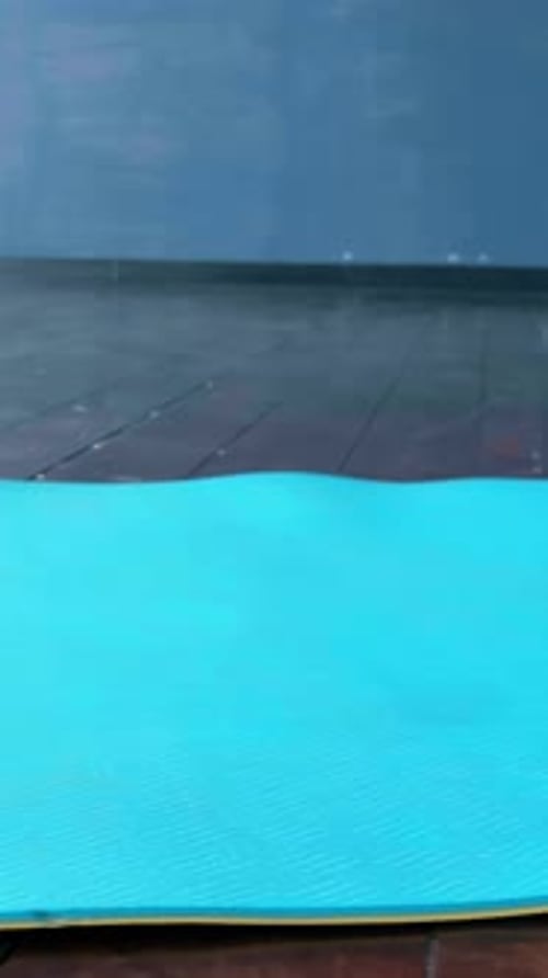 Gros plan du pied d'une personne en mouvement sur un tapis de yoga bleu mettant en valeur la flexibilité et l'équilibre lors d'une