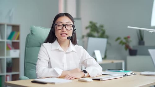 Friendly Businesswoman in Headset Talking in Office