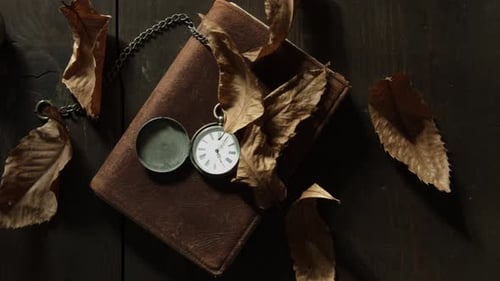 View over a pocket watch lying on top of an old book