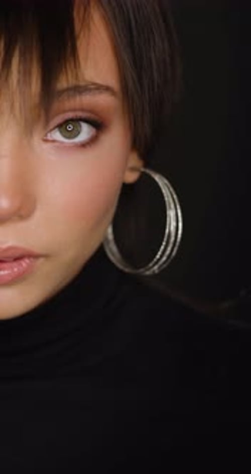 Close up of woman with earring smiling indoors