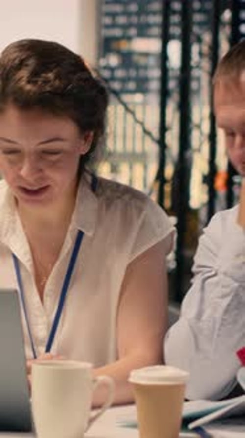 Vertical Video Team Collaboration in a Corporate Office Environment with Laptop and Reports