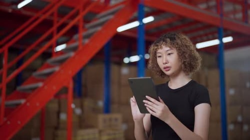 Warehouse employee in a black shirt uses a tablet