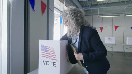 Female Volunteer Preparing Voting Booths in American Polling Place Adult