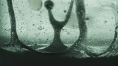 Die Hochgeschwindigkeits-Zeitlupe des in Wasserblasen fließenden Öls steigt langsam nach oben.