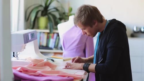Young Man Sewing, Designing Clothes in Studio
