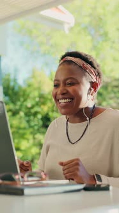 Smiling Woman Using Laptop for Video Call at Home