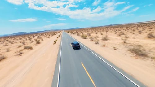 Car on a highway in the desert. Aerial Drone FPV