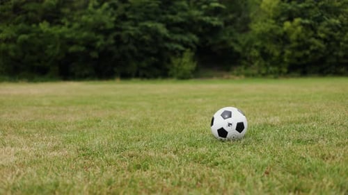 Man Bouncing Soccer Ball on Grassy Field