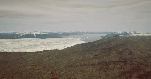 Majestic Glacial Landscape Unfolds Under Soft Clouds in a Serene Atmosphere