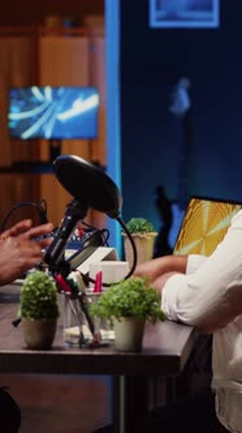 Vertical Video Influencer Recording Podcast with Guest Using Professional Equipment in Home Studio