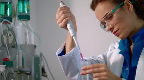 Woman Scientist Uses Pipette in Medical Lab