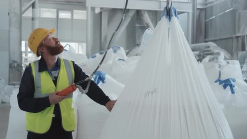 Man In Workwear Using Lifting Hoist