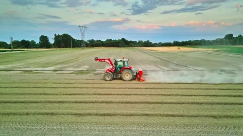 Tractor Working in a Field Surrounded by Farmlands - Aerial View